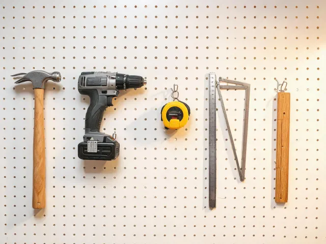 Small hand tools on a workshop pegboard